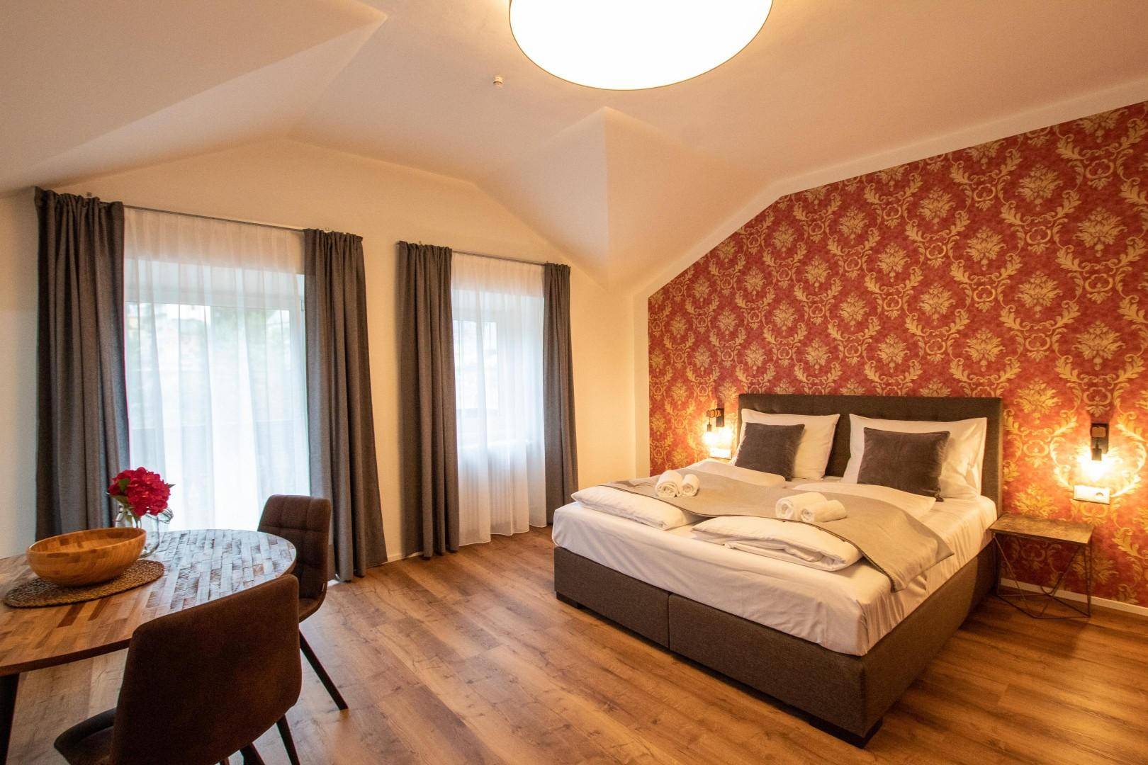 Helles Studio-Apartment mit Doppelbett, Esstisch und Dachschräge.
