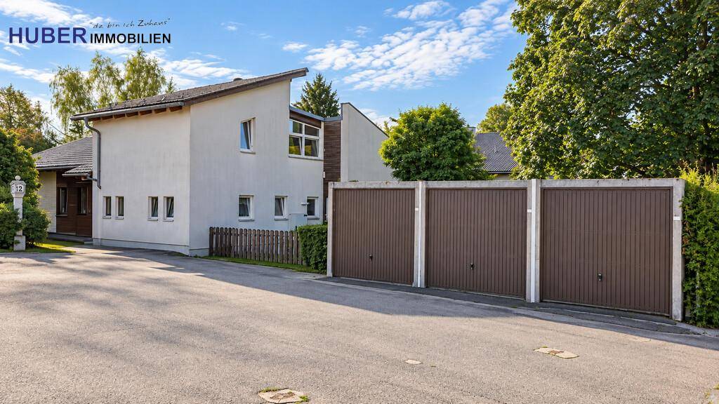 Vorderansicht des Hauses mit Garagen und Zufahrt in einer ruhigen Wohngegend.