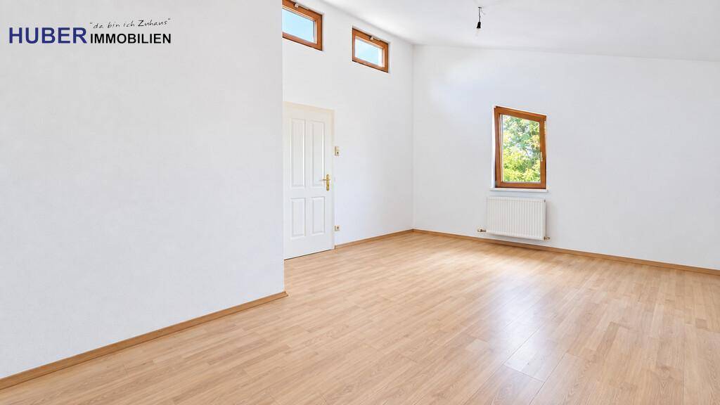 Geräumiges Zimmer mit hoher Decke, Laminatboden und einem Fenster für natürliches Licht.