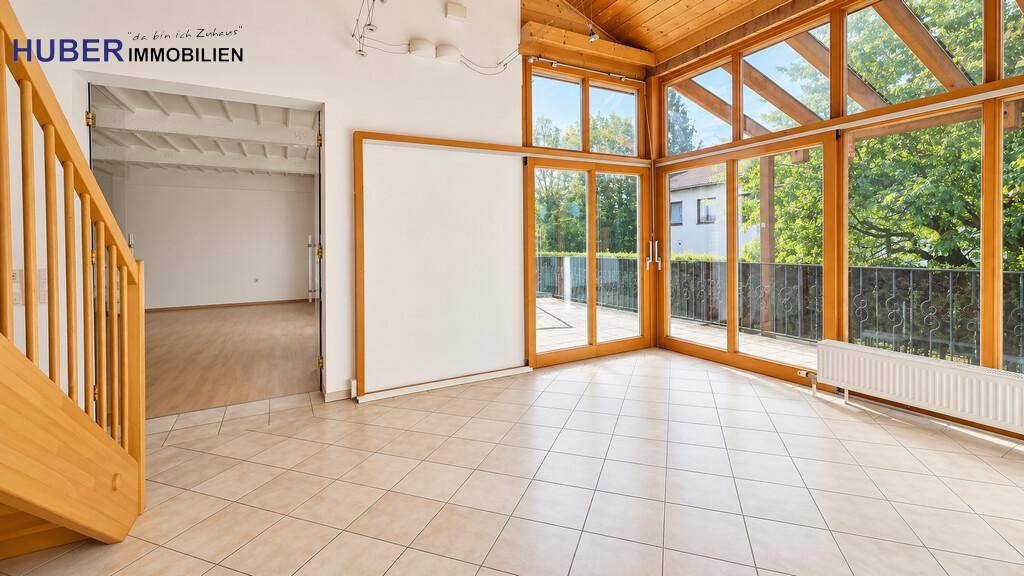 Geräumiger Wohnbereich mit Fliesenboden und direktem Zugang zum sonnigen Wintergarten.