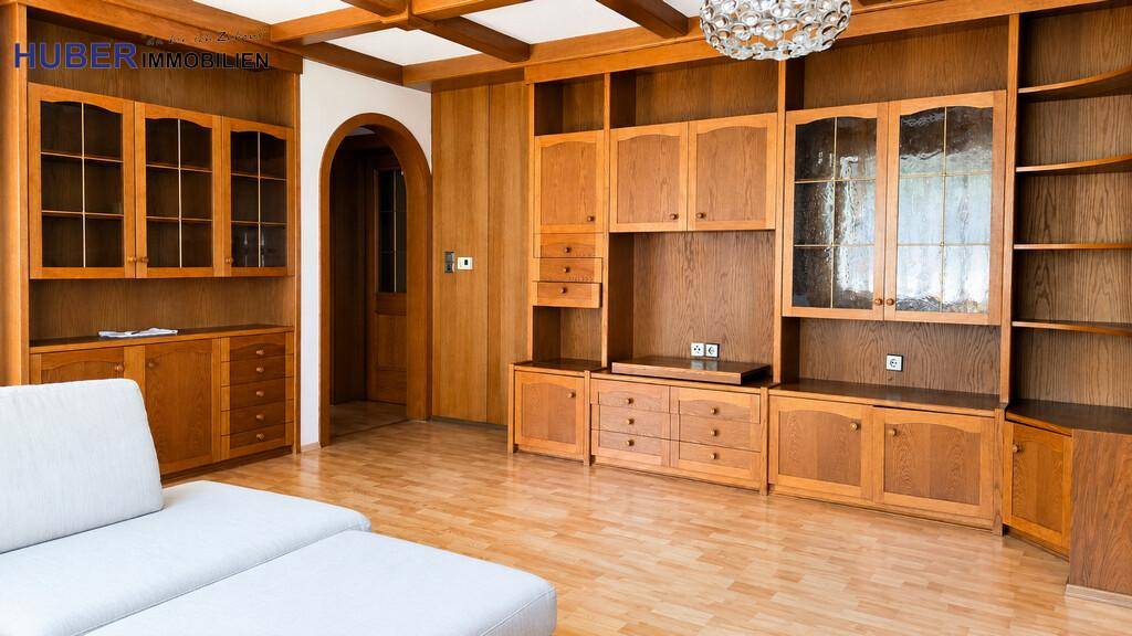 Wohnzimmer mit umfangreicher Holzschrankwand, Laminatboden und traditionellem Charme.