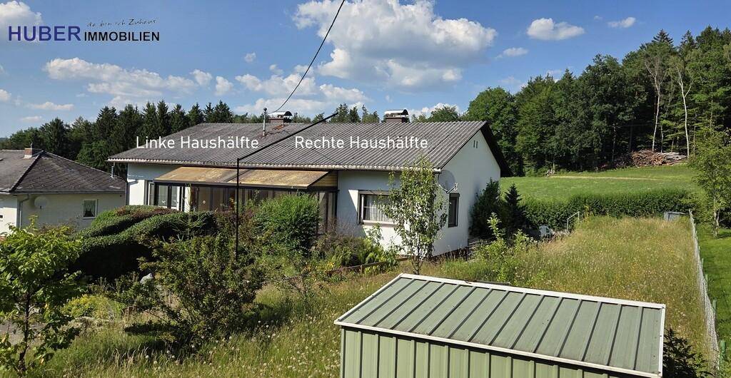 Außenansicht einer Doppelhaushälfte mit Garten, Gartenhaus und angrenzendem Waldgebiet.