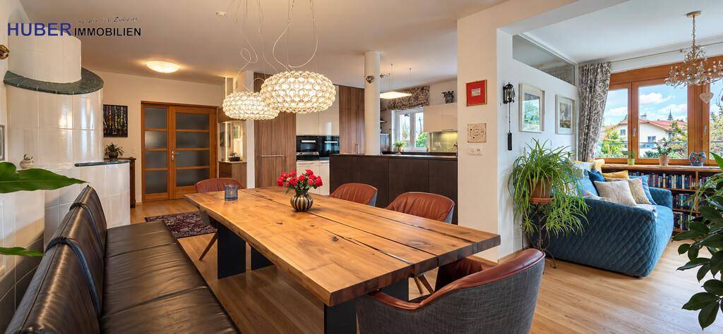 Geräumiger Wohn-Essbereich mit Holztisch, Sitzbank und Blick in die offene Küche.