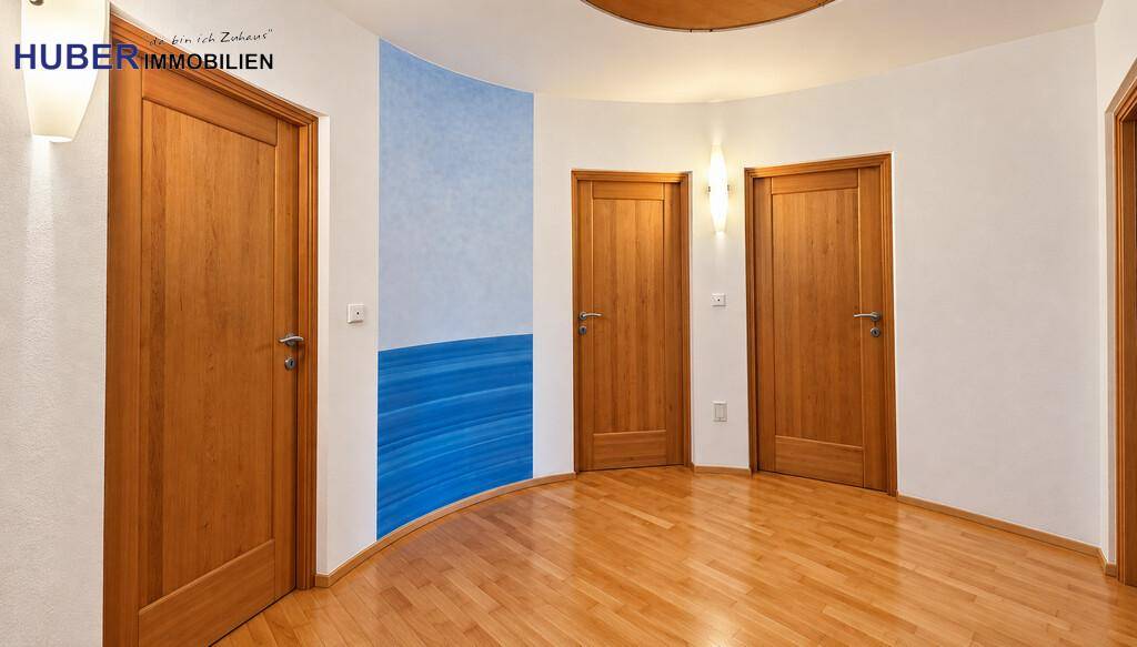 Heller Flur mit mehreren Holztüren und einer dekorativen blauen Wandgestaltung.