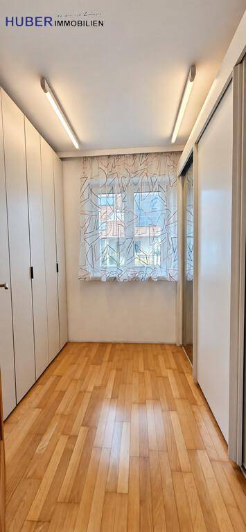 Praktischer Ankleideraum mit Einbauschränken und Fenster für Tageslicht.