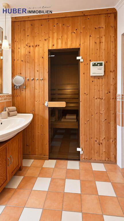 Badezimmer mit einer holzvertäfelten Sauna, die zum Entspannen einlädt.
