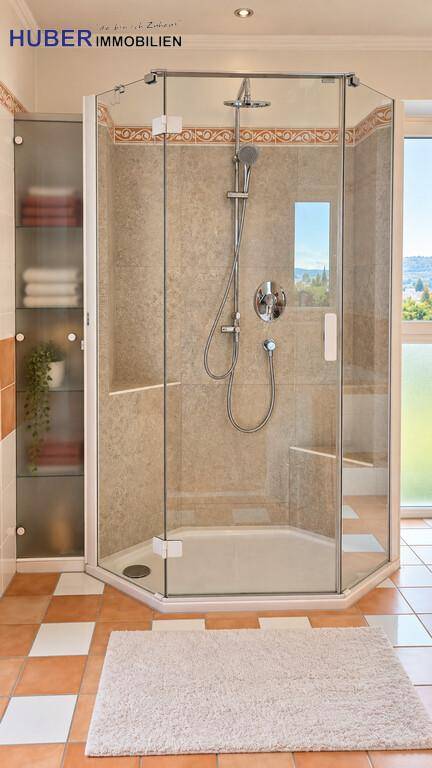 Moderne Duschkabine mit Glaswänden und Fliesenboden in einem hellen Badezimmer.