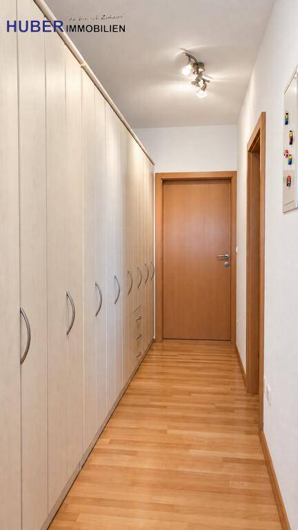 Langer Flur mit Einbauschränken und Holzboden, bietet viel Stauraum.