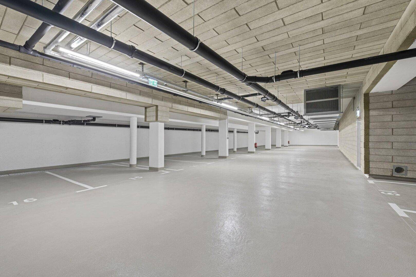 Geräumige Tiefgarage mit markierten Stellplätzen und guter Beleuchtung.