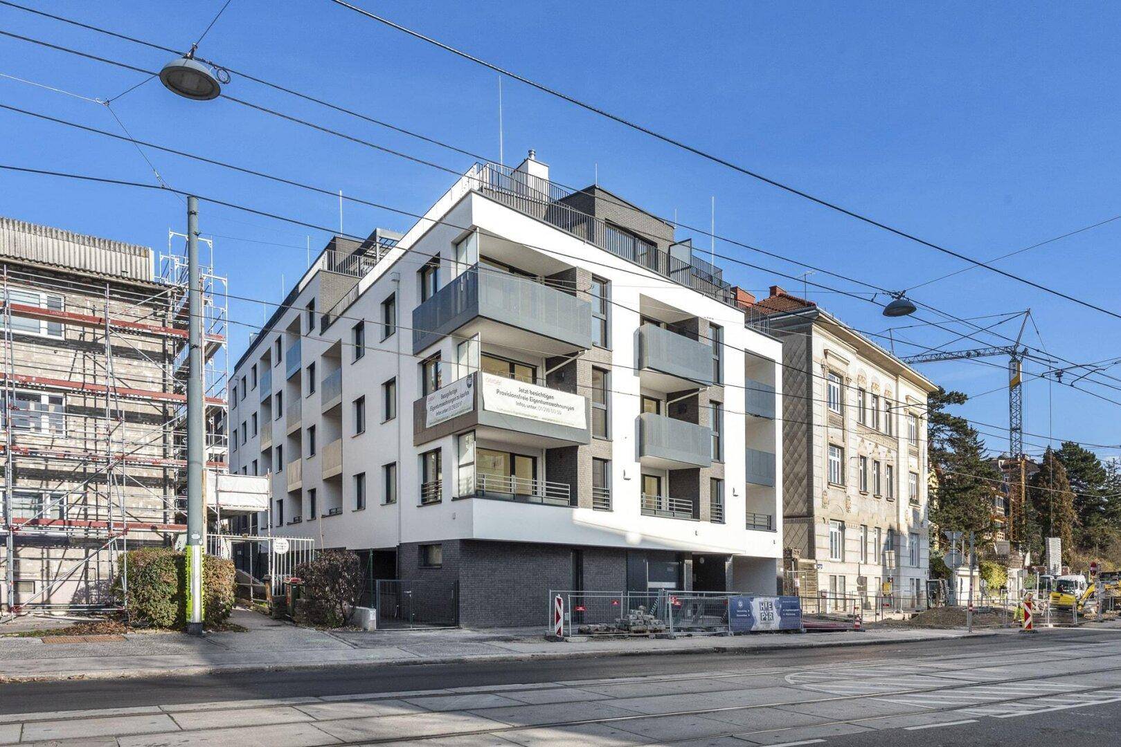 Modernes Mehrfamilienhaus mit Balkonen und zeitgenössischer Architektur in städtischer Umgebung.