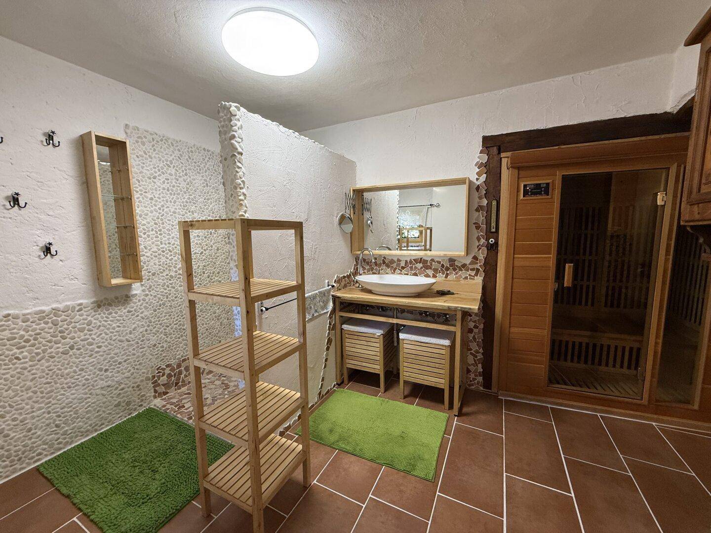 Modernes Badezimmer mit Sauna, begehbarer Dusche und Terrakotta-Bodenfliesen.