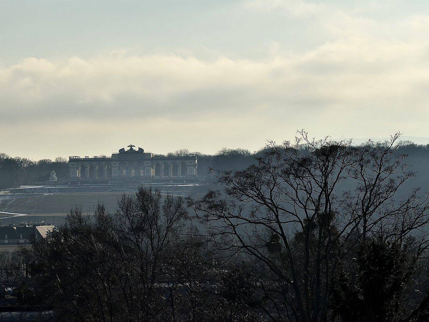Malerischer Fernblick auf ein historisches Gebäude inmitten einer winterlichen Landschaft.