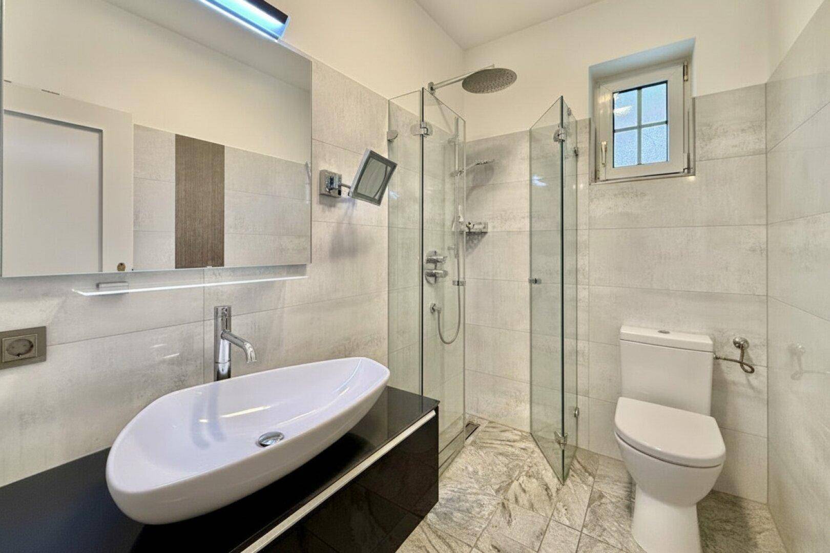 Modernes Badezimmer mit begehbarer Dusche, Einzelwaschbecken und Fenster für Tageslicht.