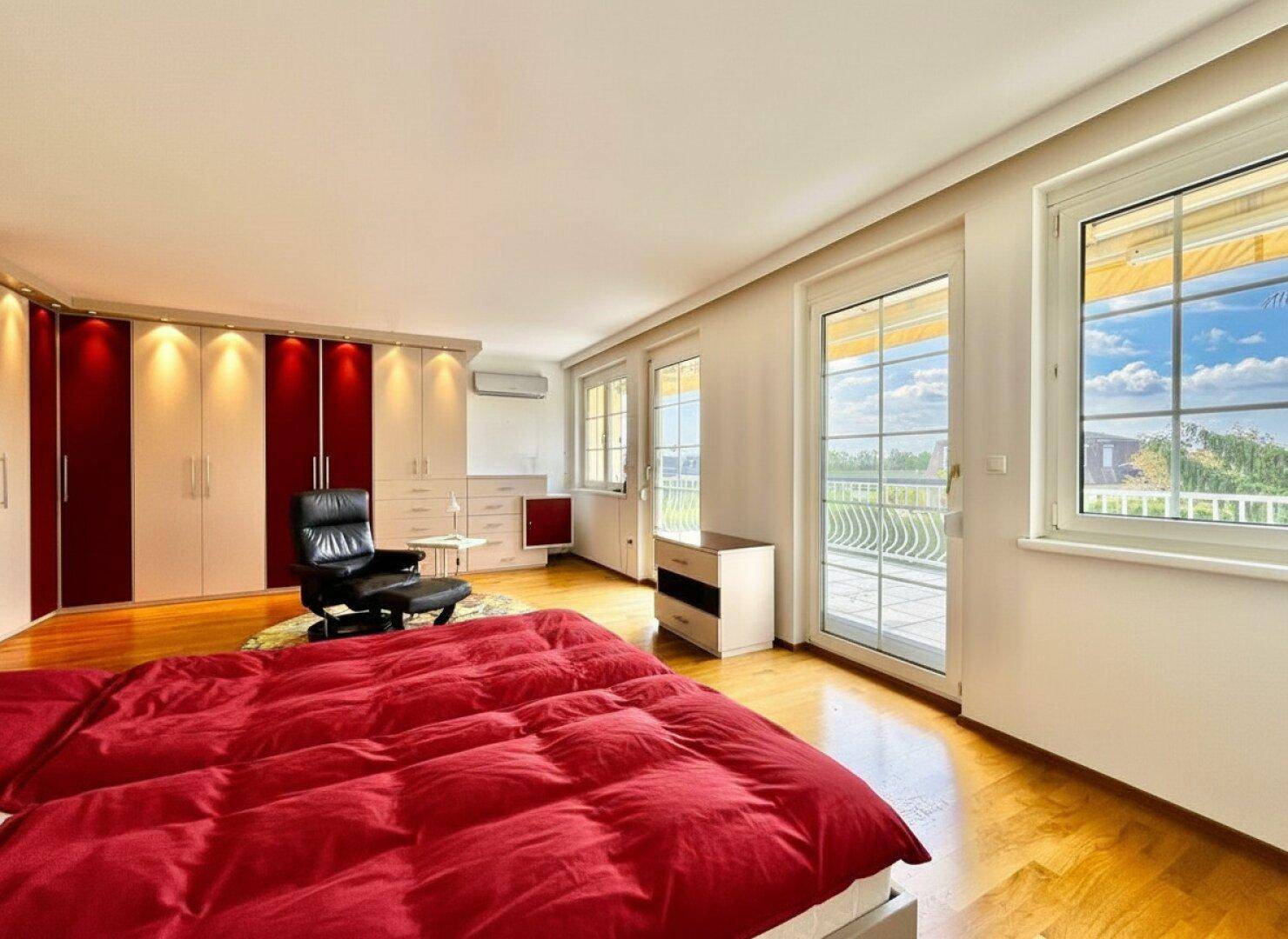Helles Schlafzimmer mit Holzfußboden, Einbauschränken und Zugang zur Terrasse.