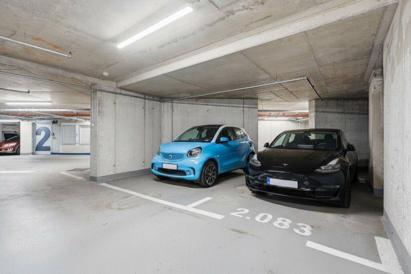 Tiefgarage mit zwei Stellplätzen und Betonwänden.