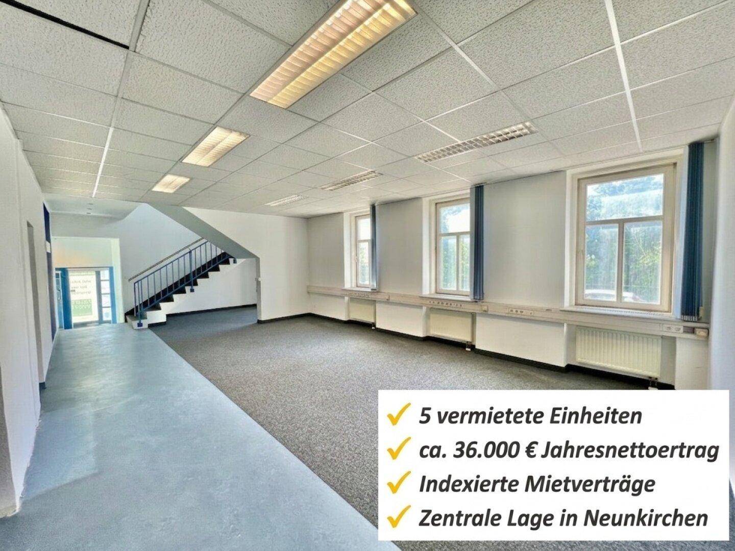 Geräumiger Bürobereich mit Teppichboden, Rasterdecke und Treppenaufgang.