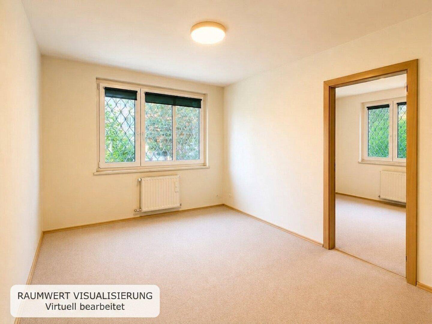 Leerer Raum mit Teppichboden, Heizkörper und Fenster mit Blick ins Grüne.