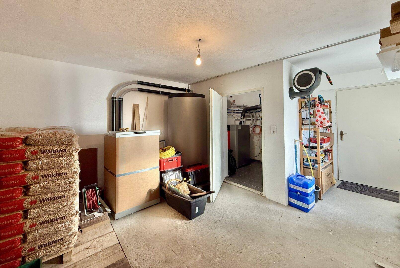 Funktionaler Hauswirtschaftsraum mit Warmwasserspeicher und Lagerung für Holzpellets.