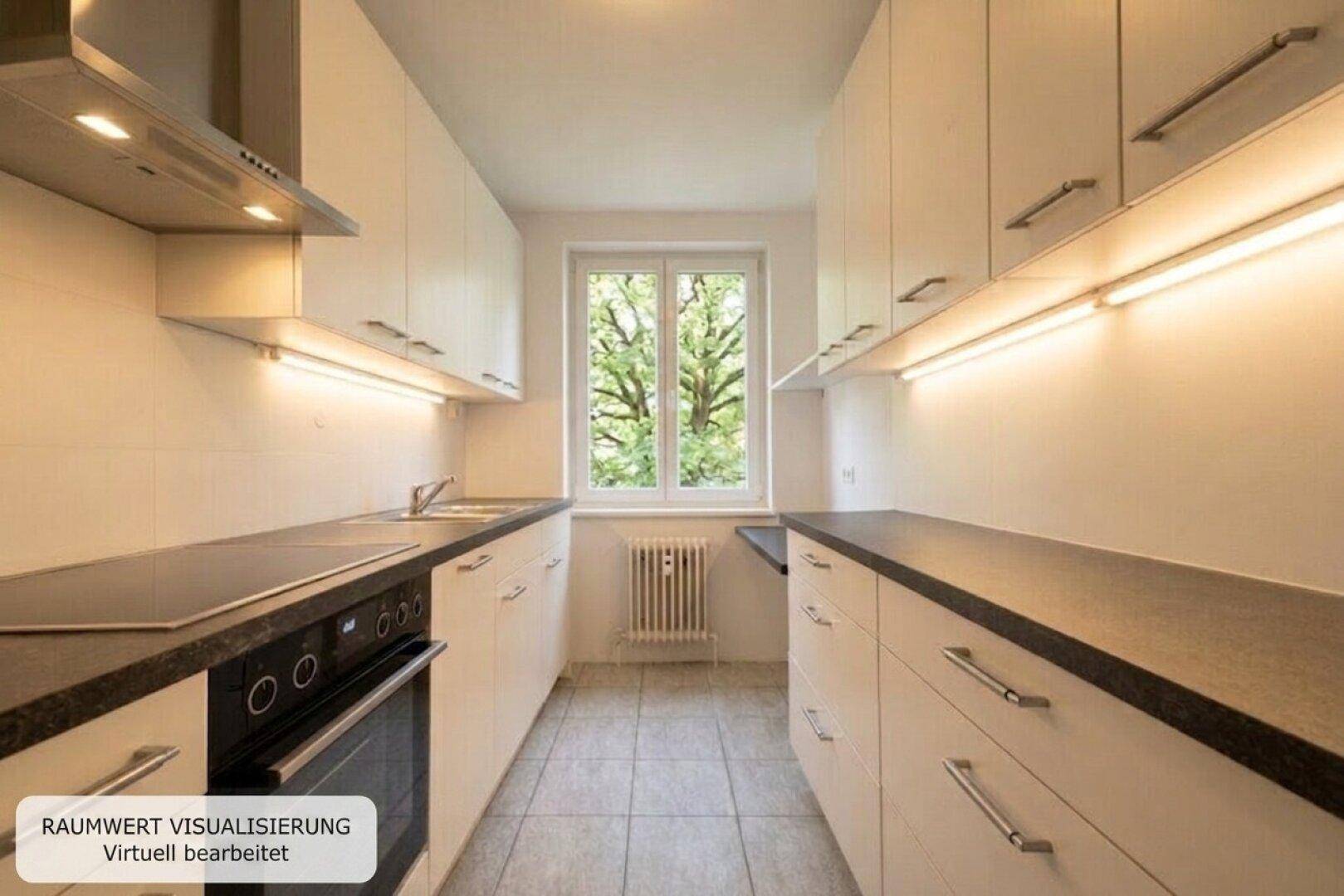 Funktionale Küche mit weißen Einbauschränken, dunklen Arbeitsplatten und Fensterblick ins Grüne.