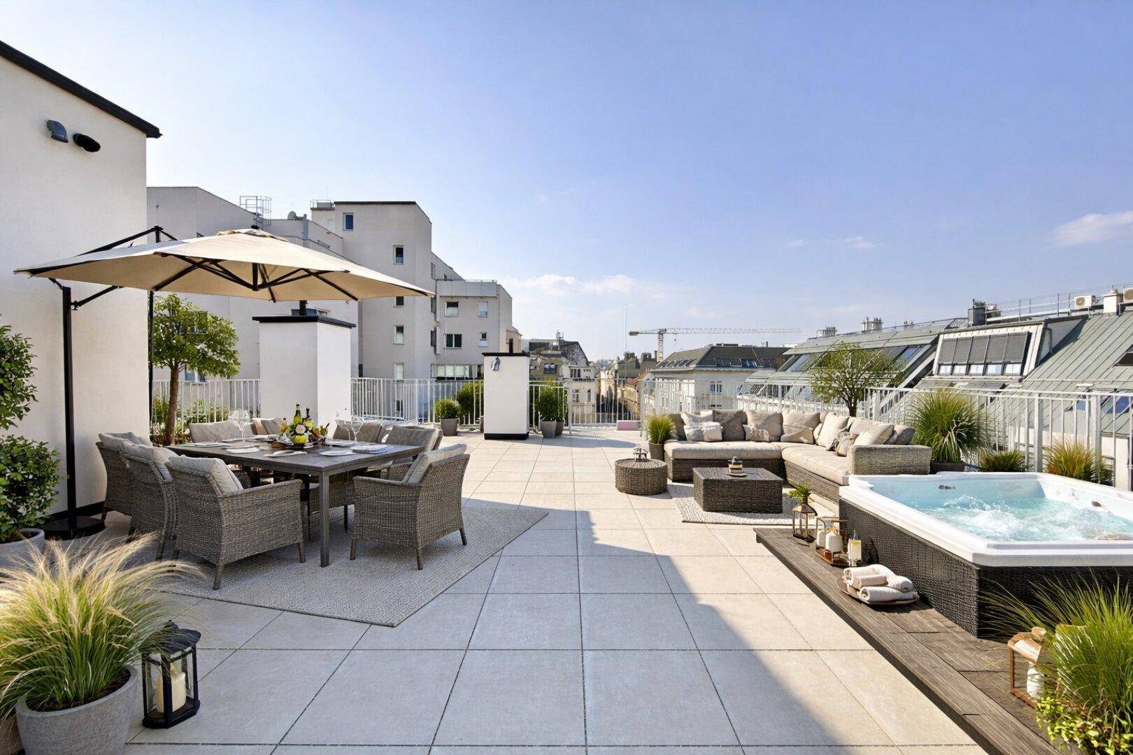 Geräumige Dachterrasse mit luxuriösem Whirlpool, Lounge-Bereich und Essplatz im Freien.
