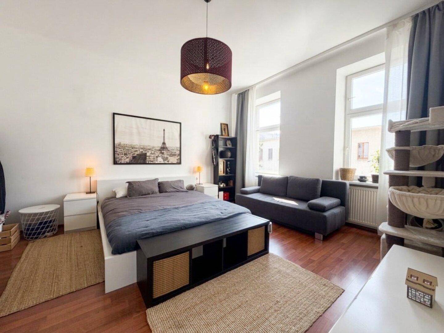 Freundliches Schlafzimmer mit Doppelbett, Holzboden und Teppichen.