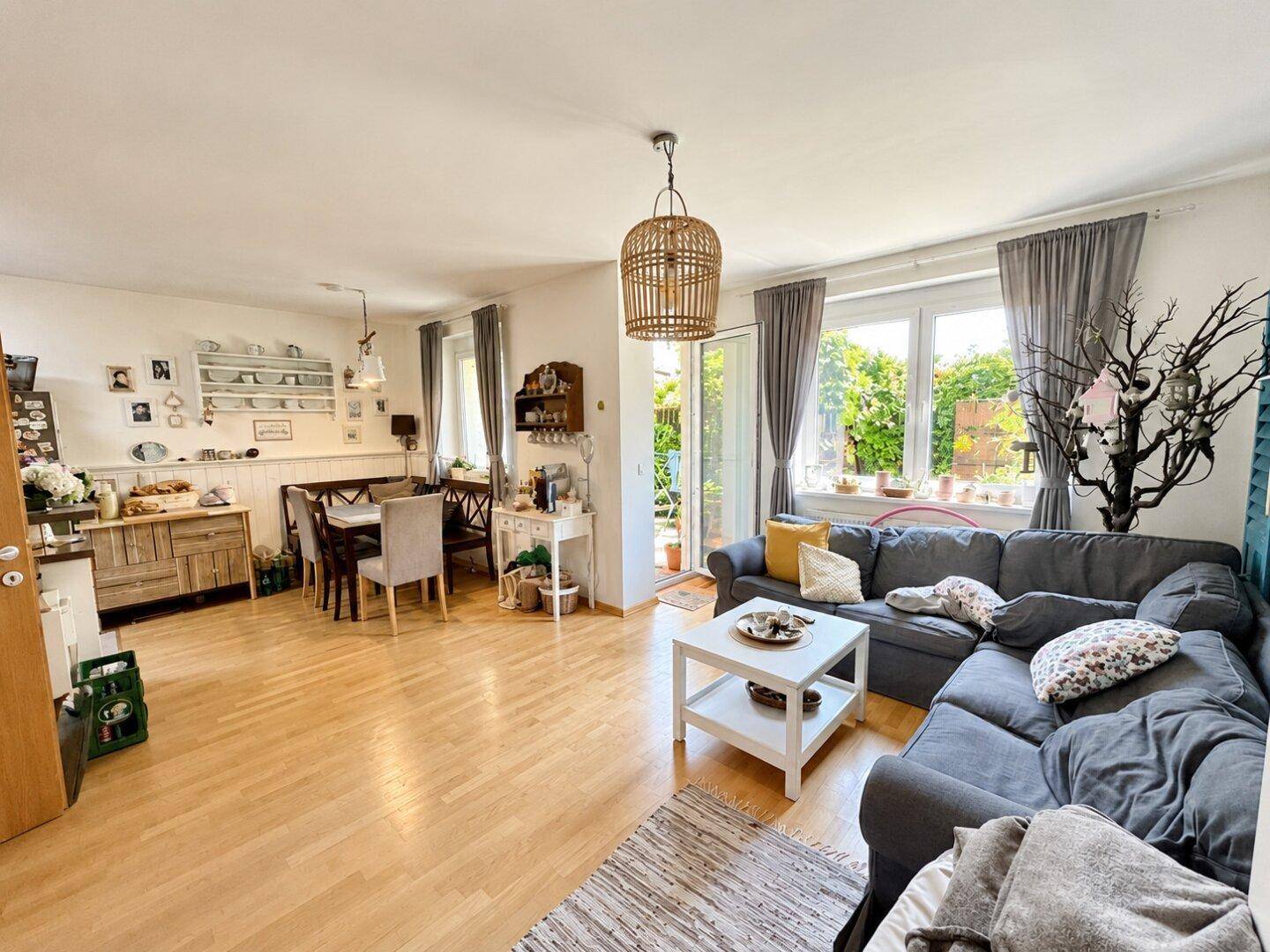 Heller Wohn- und Essbereich mit Holzboden, gemütlichem Sofa und direktem Zugang zur Terrasse.