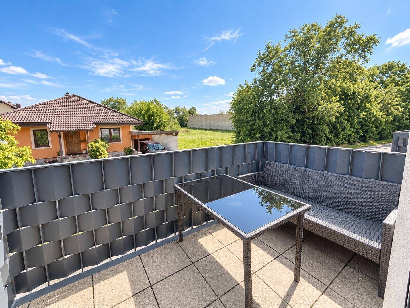 Gemütlicher Balkon mit Sitzgelegenheiten und Blick ins Grüne, ideal zum Entspannen im Freien.