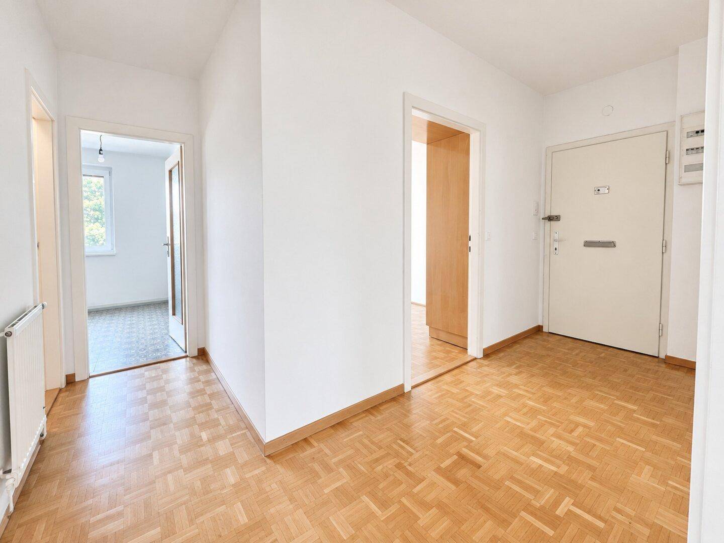 Geräumiger Flur mit Parkettboden und mehreren Türen zu angrenzenden Zimmern.