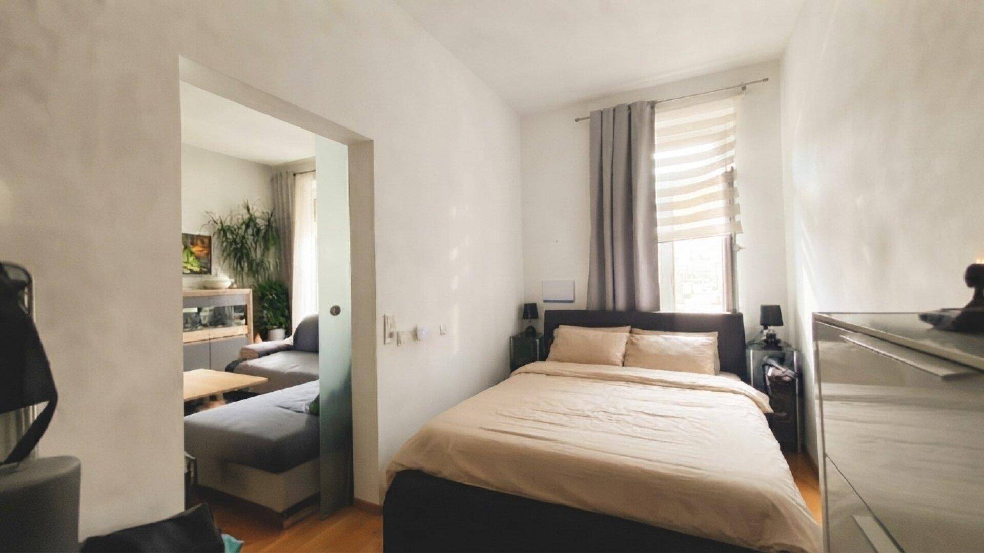 Schlafzimmer mit Doppelbett und Zugang zum angrenzenden Wohnbereich.