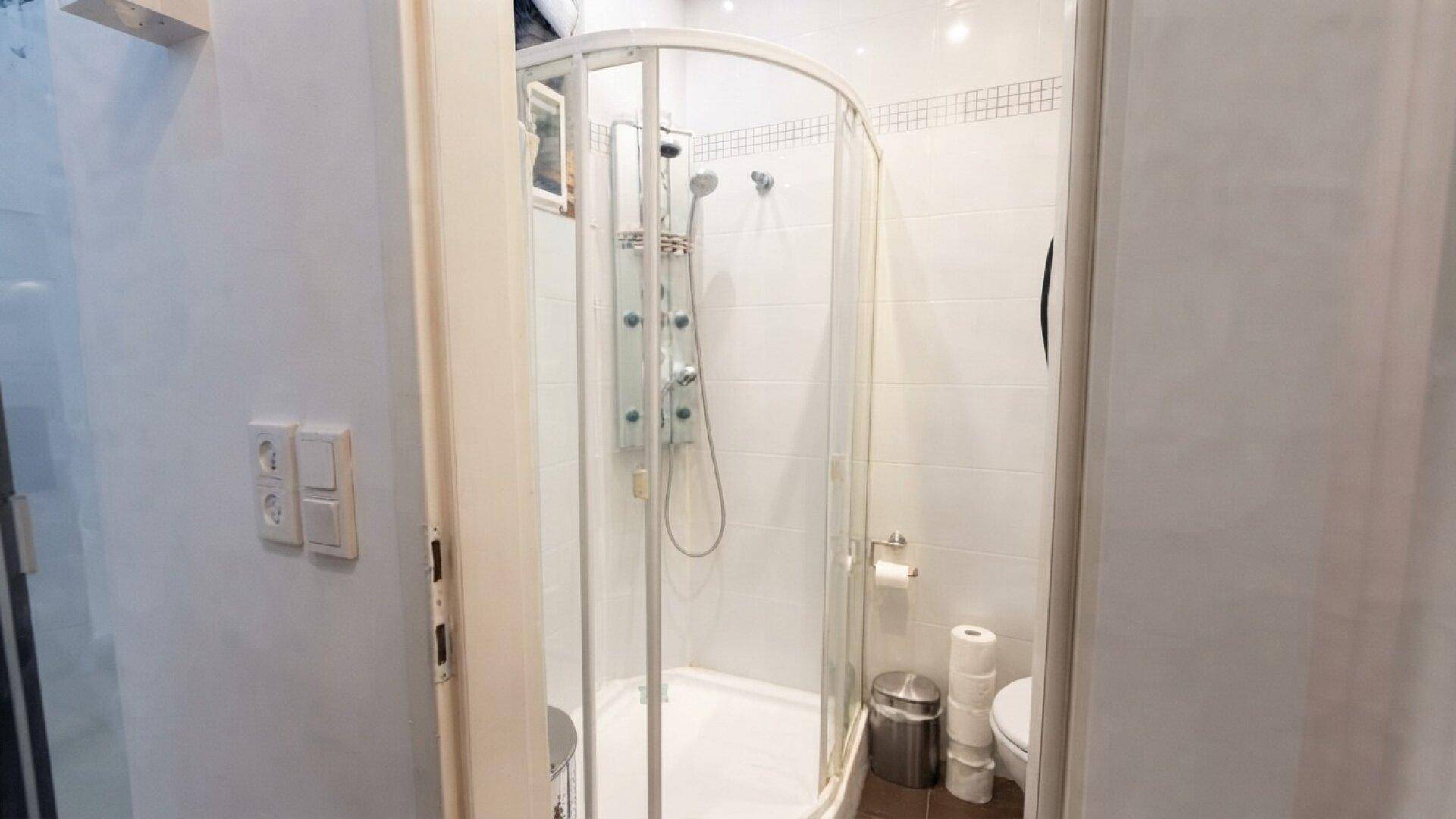 Badezimmer mit Duschkabine und Toilette, funktional und hell gestaltet.