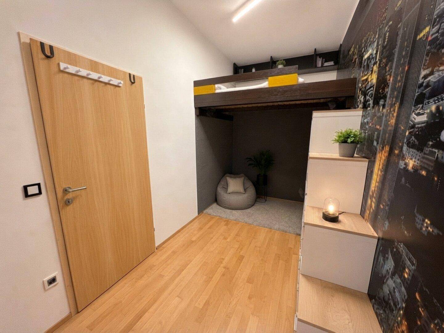 Modernes Schlafzimmer mit Hochbett, Holzfußboden und urbaner Tapete, bietet zusätzlichen Raum darunter.