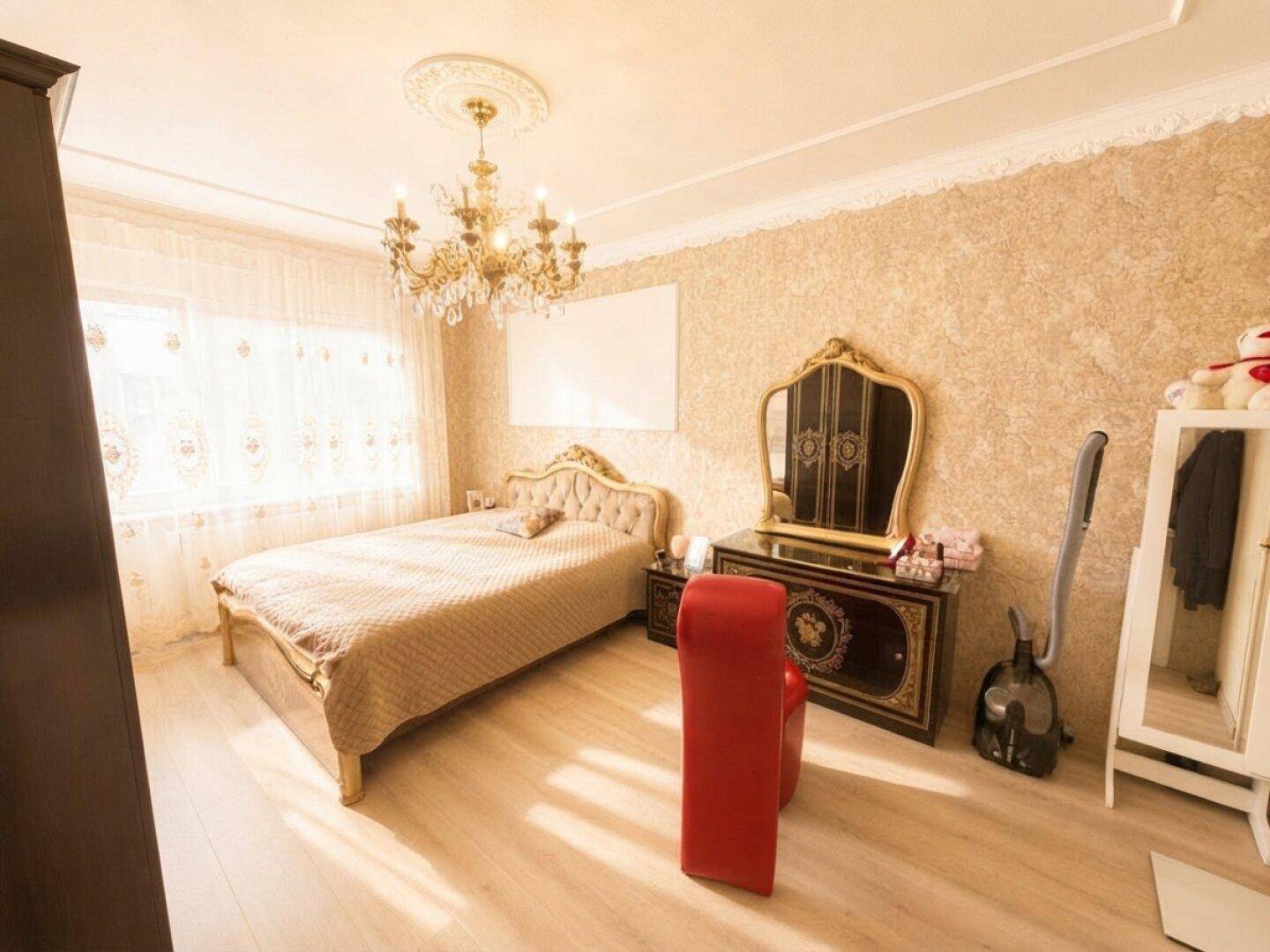 Elegantes Schlafzimmer mit Kronleuchter, gemusterter Tapete und hellem Laminatboden.