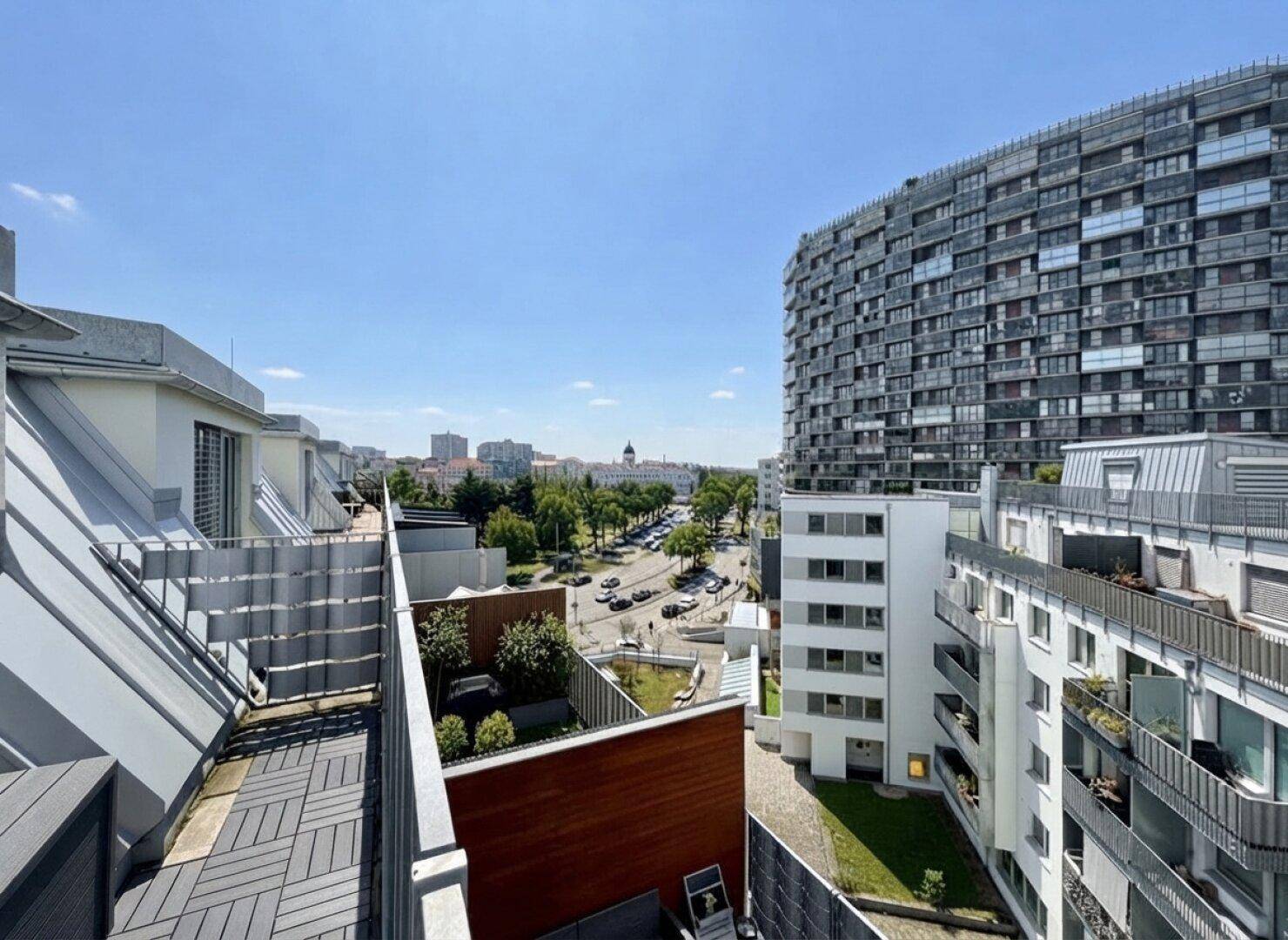 Weitläufiger Blick über die Stadt von einer Dachterrasse mit moderner Architektur.