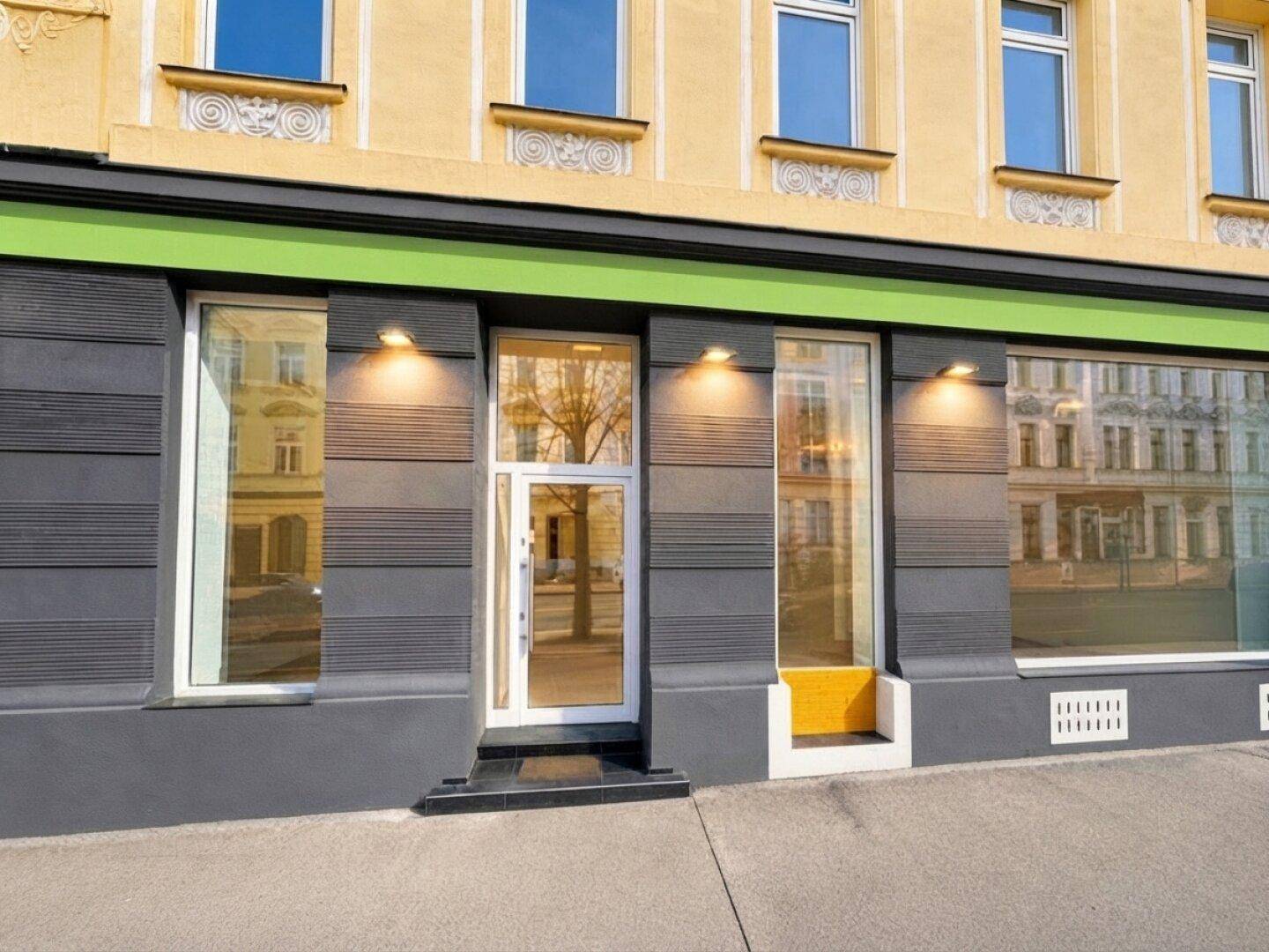 Fassade eines Gebäudes mit modernisiertem Erdgeschoss und großen Schaufenstern, ideal für Gewerbeflächen.