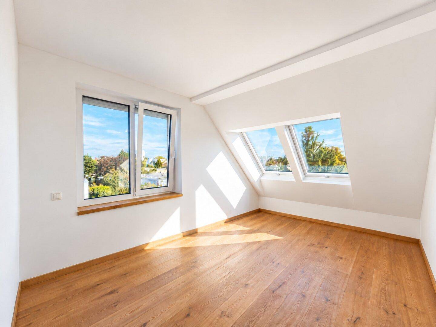 Sonniges Schlafzimmer mit Holzboden und mehreren Fenstern, darunter Dachfenster.