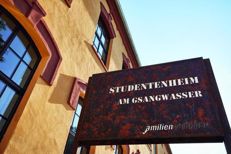 Rostiges Schild des Studentenheims am Gsangwasser vor der historischen Fassade des Gebäudes.