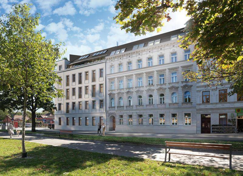 Ansicht der modernen Gebäudefassade von der Straße aus, umgeben von Bäumen und Grünflächen.