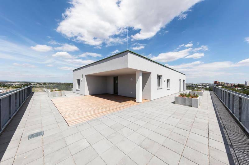 Große Dachterrasse mit Fliesen und Holzdeck, bietet einen weiten Panoramablick über die Umgebung.