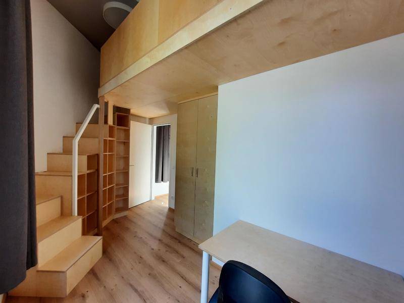 Gemütlicher Wohnraum mit Holz-Hochbett, integrierten Regalen und Schreibtisch, optimiert für kleine Flächen.