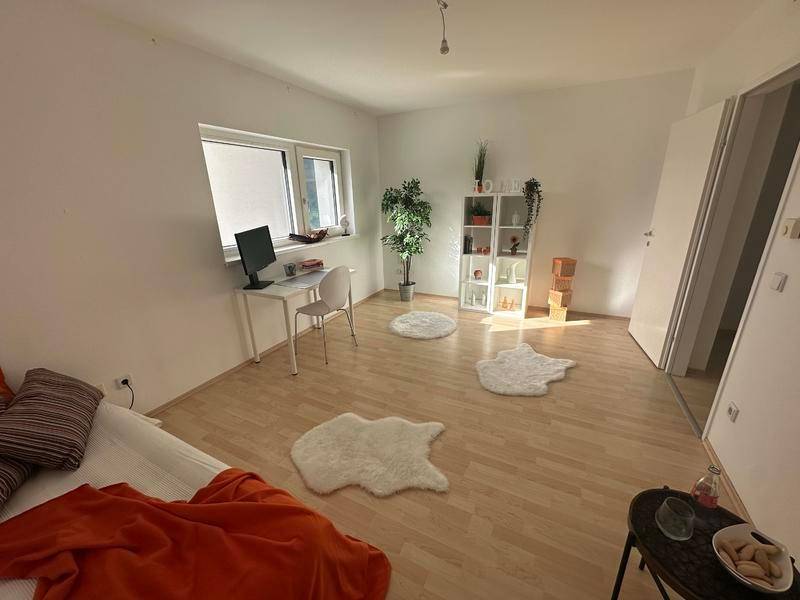 Helles Zimmer mit Schreibtisch, Regal und Blick nach draußen, ideal als Gäste- oder Arbeitszimmer.
