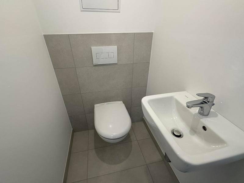 Kleines Gäste-WC mit wandhängender Toilette und modernem Waschbecken.