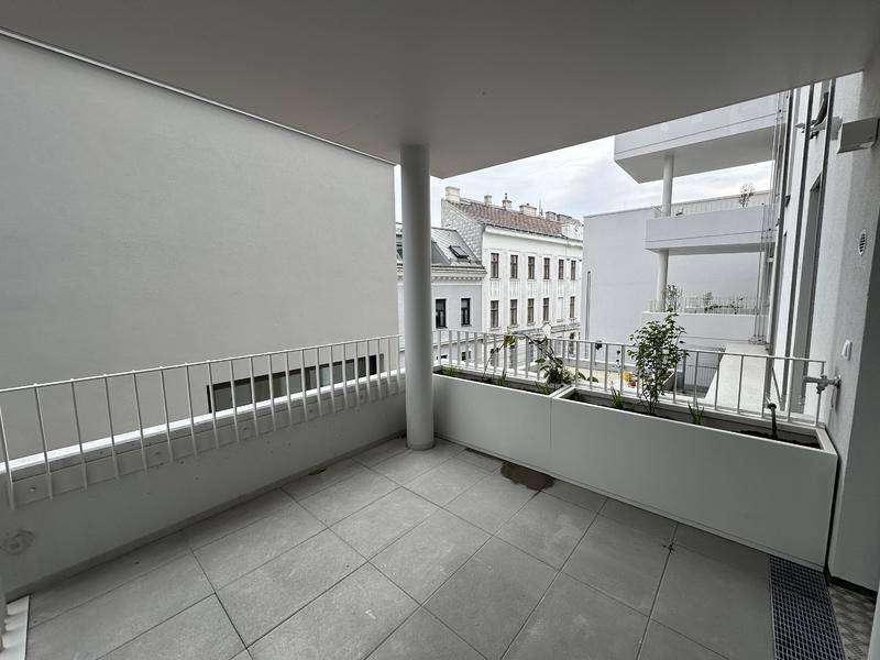 Balkon mit Pflanzkästen und Blick auf die umliegenden Gebäude der Stadt.