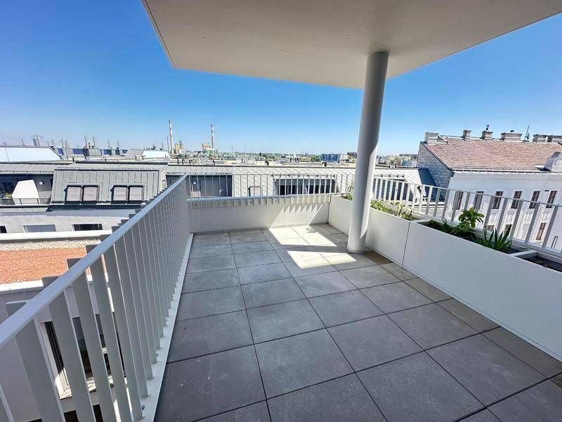 Geräumiger Balkon mit Fliesenboden und weitem Blick über die Dächer der Stadt.