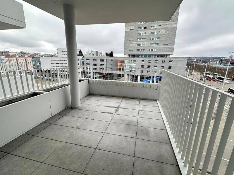 Moderner Balkon mit Fliesenboden und Blick auf die städtische Umgebung, ausgestattet mit Pflanzkästen.
