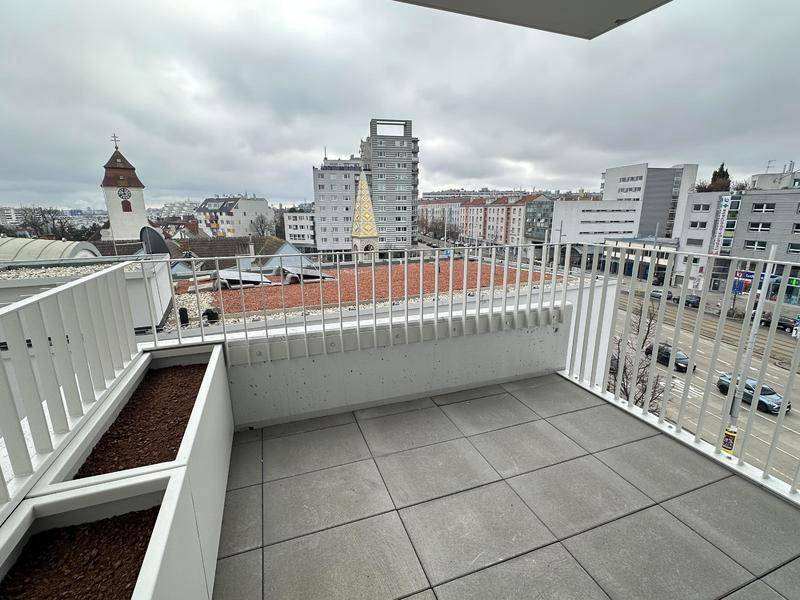 Geräumiger Balkon mit Fliesenboden und Stadtblick, ideal für entspannte Stunden im Freien.