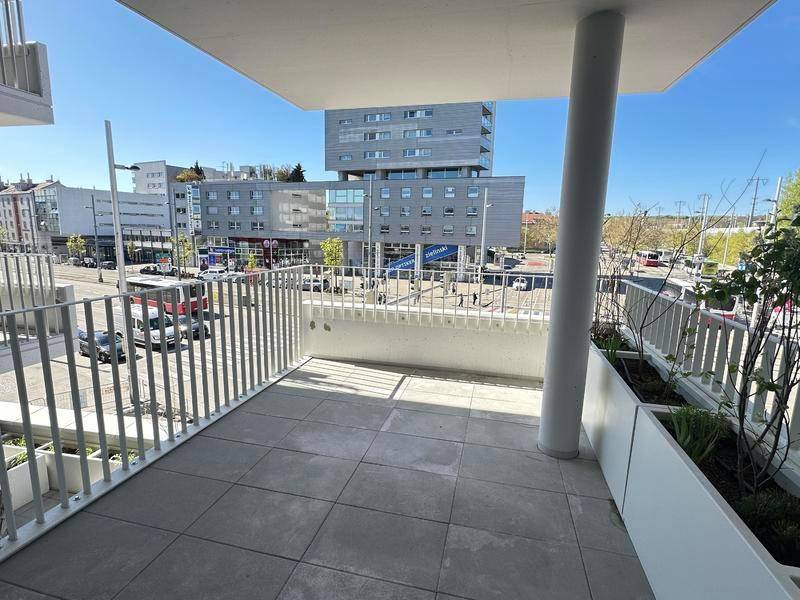 Moderner Balkon mit Fliesenboden und Blick auf die städtische Umgebung.