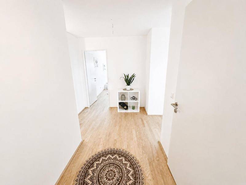 Heller Flur mit Parkettboden und schlichtem, modernem Design.