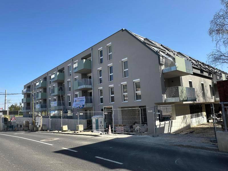 Neubau-Wohngebäude mit moderner Fassade und Balkonen, noch im Bau oder frisch fertiggestellt.