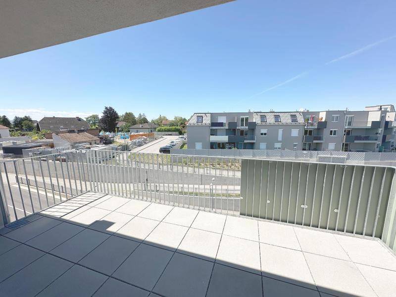 Geräumiger Balkon mit Fliesenboden und Blick auf die umliegende Wohngegend.