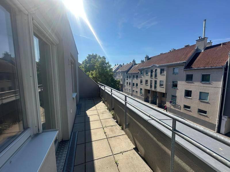 Sonniger Balkon mit Blick auf die gegenüberliegenden Häuser und die städtische Umgebung.